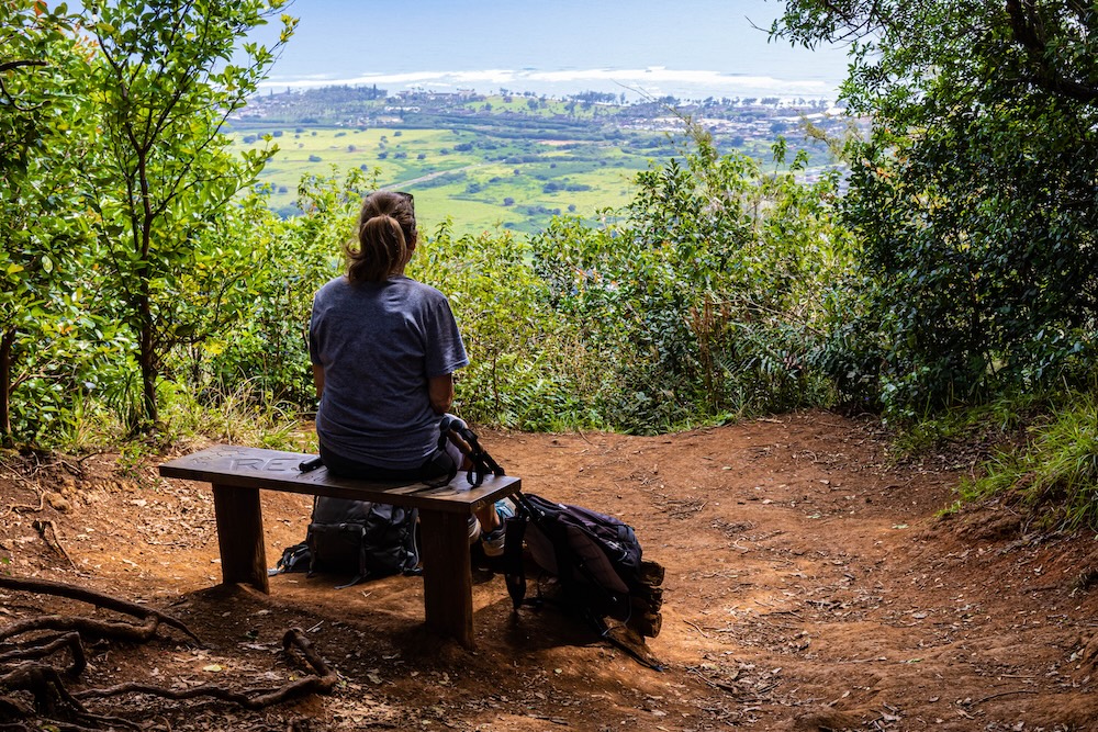 woman on bench overlooking Sleeping Giant hike in Kauai