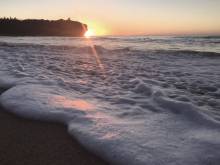 the sun rises over the pacific ocean at shipwreck&#039;s beach in kauai