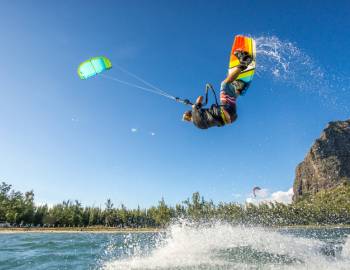 a windsurfer flips over the water in a cover near poipu