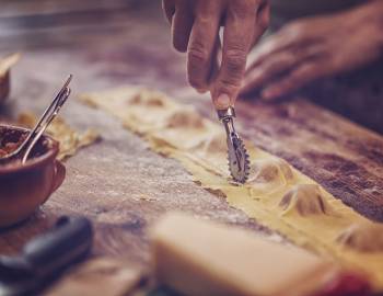 person hand cutting ravioli