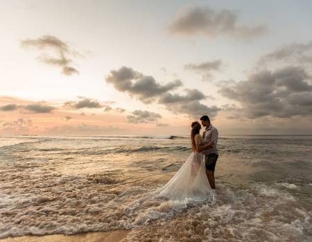 just married couple standing in water at the beach