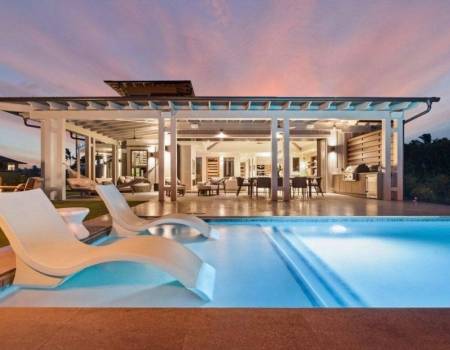 large pool deck and covered patio at sunset in poipu