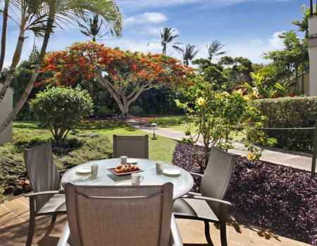 A small table and two chairs where you can view the garden at Kahala 911, a Poipu Beach vacation rental