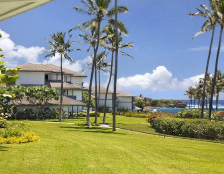 Poipu Beach vacation rental properties sit along the oceanfront in Kauai, Hawai'i