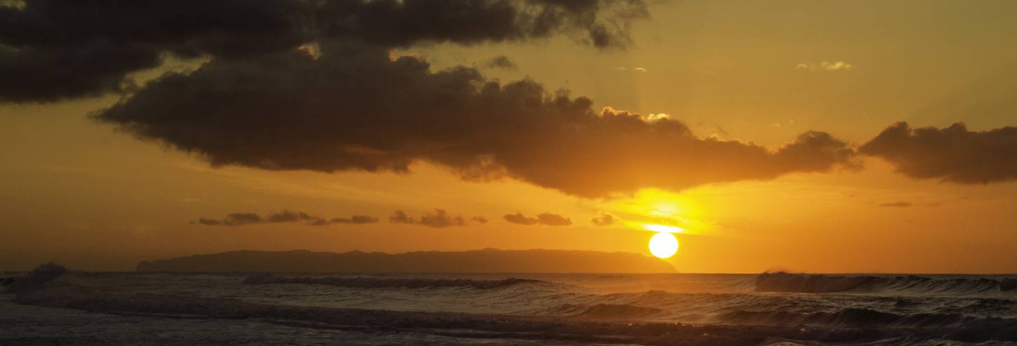 the sun sets into the pacific ocean in kauai