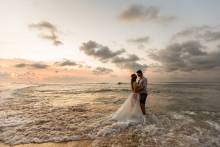 just married couple standing in water at the beach