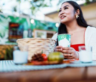 a woman sits at a poipu restaurant talking to someone off photo