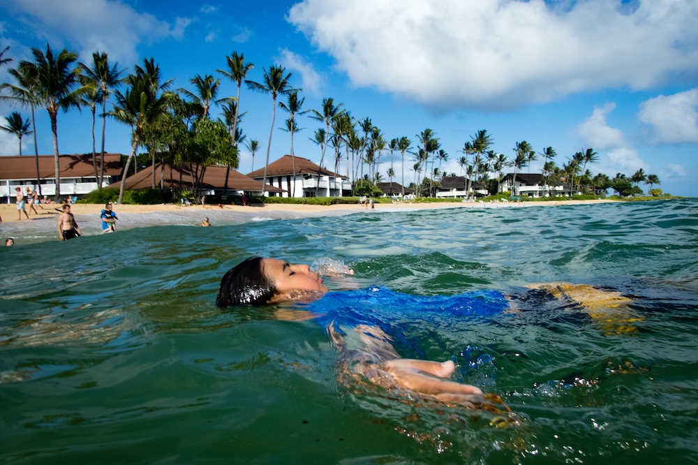 Child floating in the water at Poipu Beach
