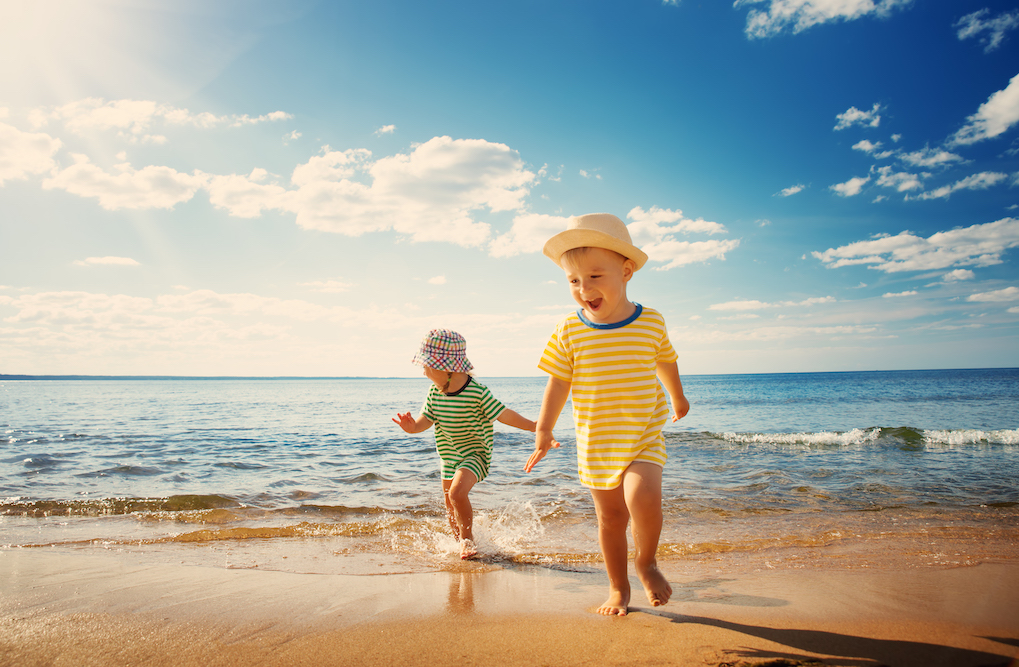two small children running on beach