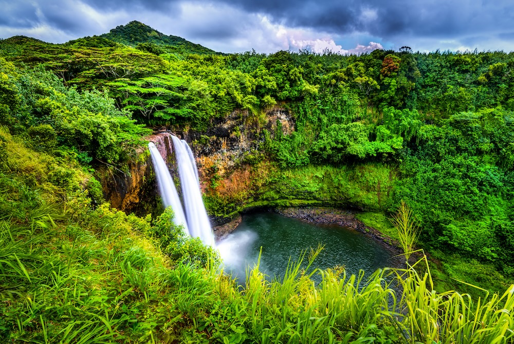 wailua falls in kauai two falls pouring over a cliff into a pool below